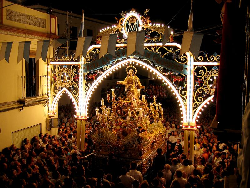 Cantillana. Procesión nocturna de la Virgen de Nuestra Señora de la Asunción bajo un arco de luces