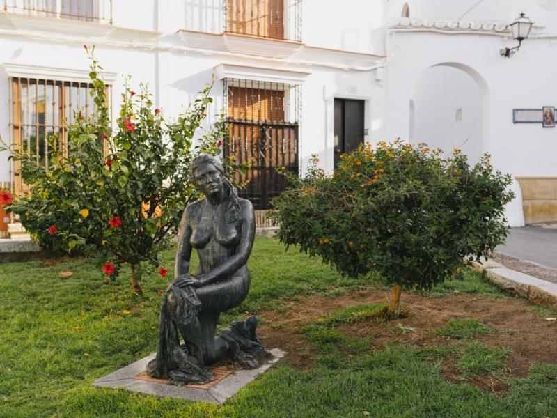 Los Palacios y Villafranca. Plaza Miguel Murube Galán con estatua de mujer en primer plano
