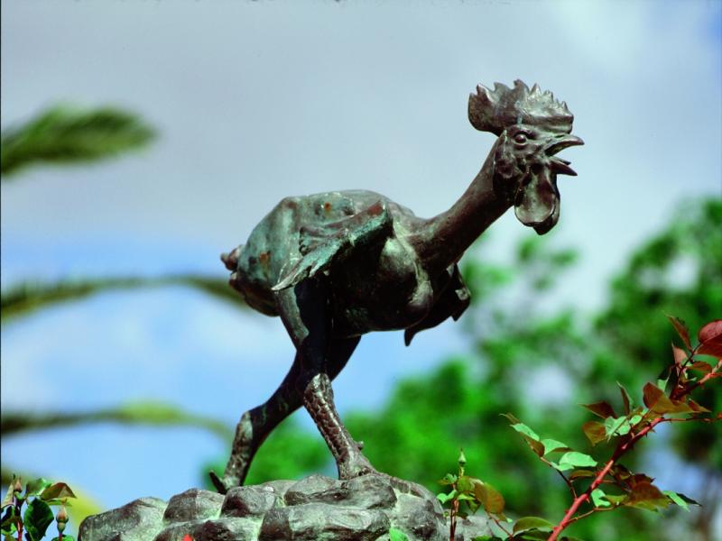 Morón de la Frontera. Escultura en bronce del Gallo de Morón con flores