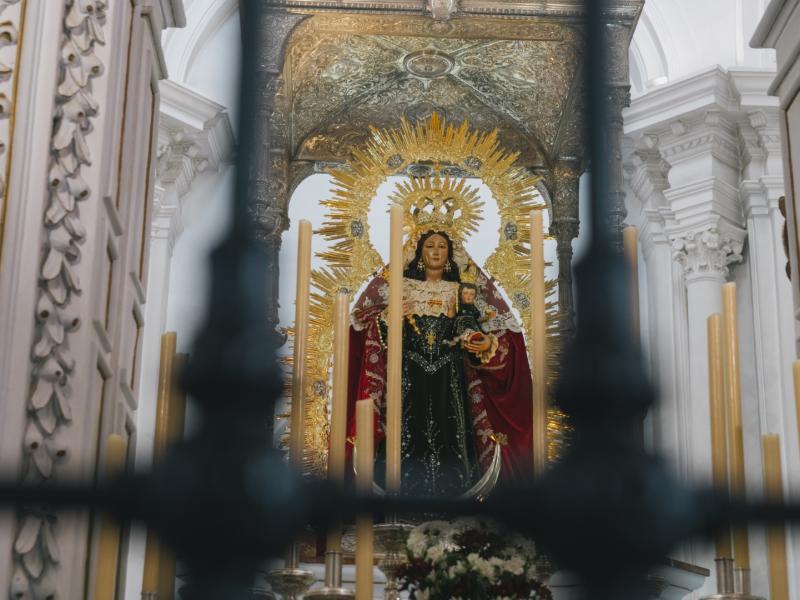 Imagen de la virgen del robledo en retablo mayor con velones delante
