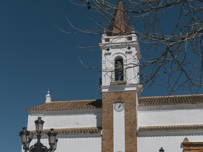 Torre de la iglesia de la purísima concepción, campanario, reloj y farol en la puerta de la iglesia, farola y banco en la plaza