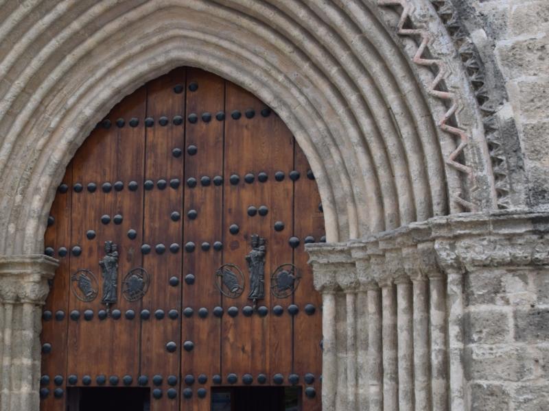 Gran puerta de entrada de madera a la iglesia de san julián con las finas columnas bordeándola