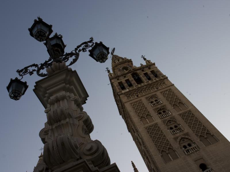 Imagen de la giralda vista desde abajo con la farola de hierro que hay en la plaza de los reyes, justo detrás de la catedral y la giralda