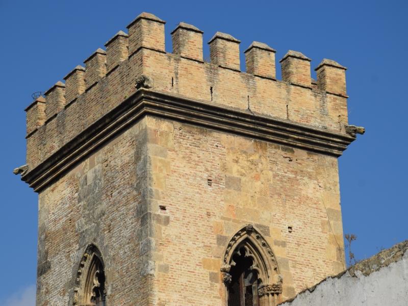 Vista de la parte superior de la torre de don fadrique románico y gótico donde se observa azotea con almenas y merlones y cuatro pequeñas gárgolas en los ángulos