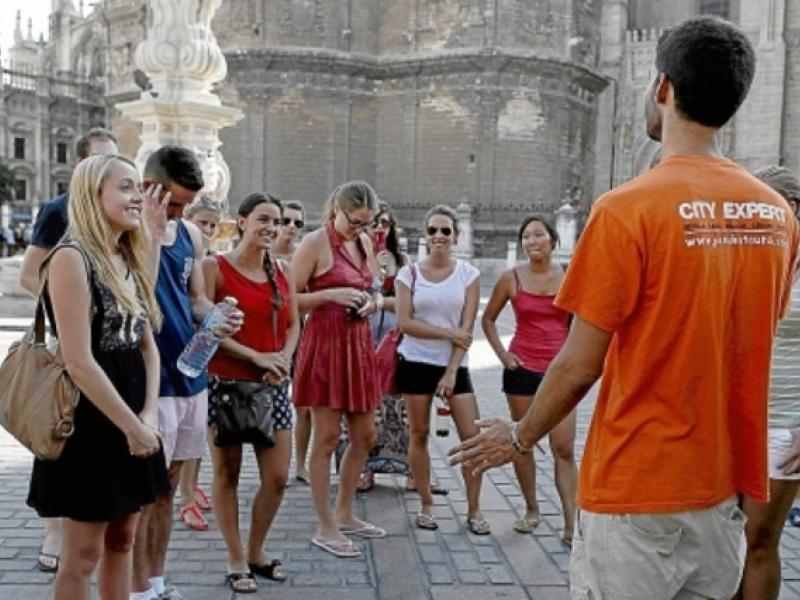 Guía profesional mostrando a un grupo de turistas la Catedral y la Giralda