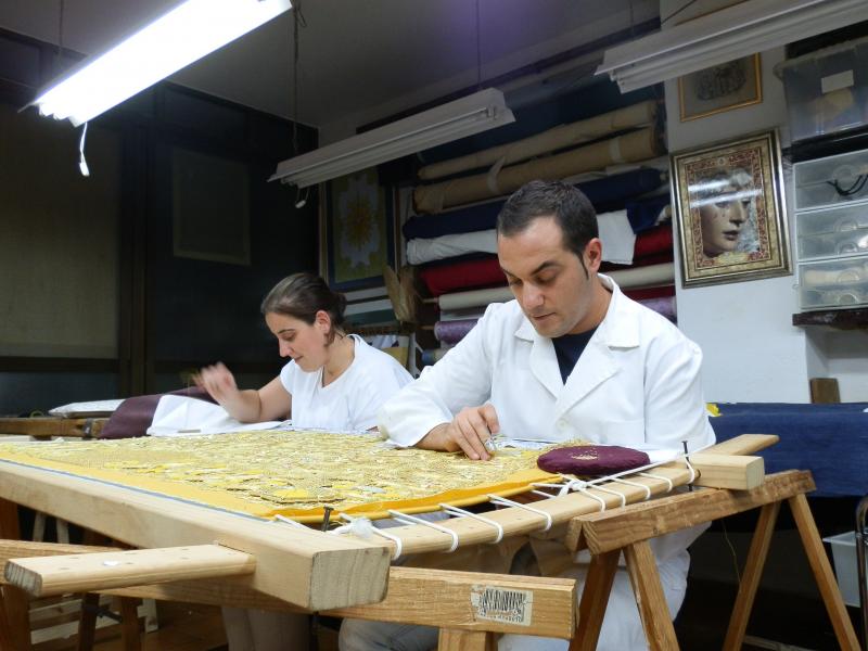 Artesanos trabajando en el taller confeccionando un bordado