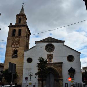 Imagen de frente del edificio completo de la iglesia con la puerta de entrada y la torre del campanario a su izquierda